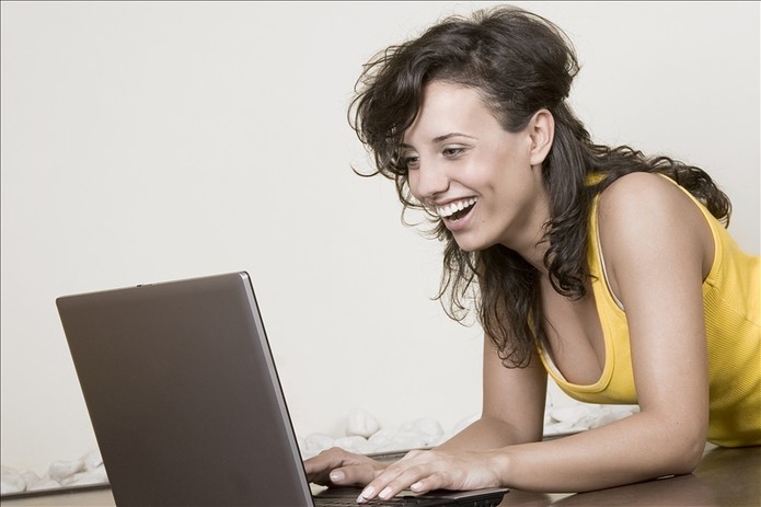Garota rindo com Laptop veloz (Foto: Pond5)