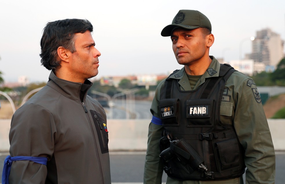 Leopoldo Lopez, que cumpria prisão domiciliar, ao lado de militar ao lado de base aérea em Caracas — Foto: Carlos Garcia Rawlins/Reuters