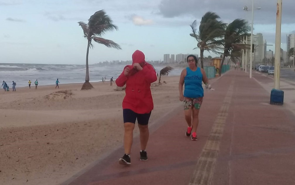 Pessoas que andam na orla de Salvador na manhã desta quarta-feira (7) encontraram dificuldades para circular no calçadão à beira da praia  — Foto: Cid Vaz/TV Bahia