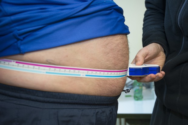 Homem obeso mede a circunferência da cintura. Uso de remédios para emagrecimento deve ser feito exclusivamente com prescrição e acompanhamento médico (Foto:  BSIP / Getty Image)