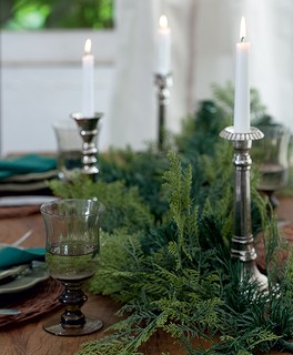 Um festão como este ou ramos naturais de pinheiro, mais velas, formam um centro de mesa original