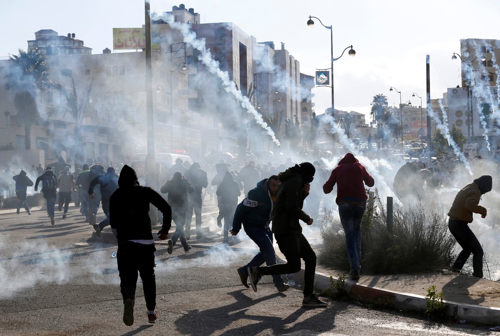 Manifestantes palestinos são alvo de bombas de gás lançadas pelas tropas de Israel perto de Ramallah (Foto: Mohamad Torokman/Reuters)