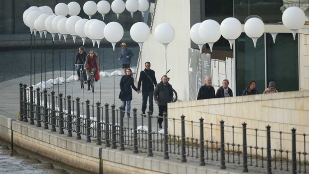 Pessoas caminham por entre linha de balões, construída para mostrar onde era o Muro de Berlim (Foto: Getty Images)