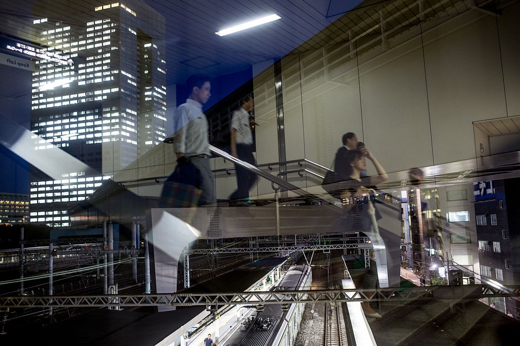 TOKYO, JAPAN - JULY 22: Office workers are seen reflected in a window as they walk to a train station in front of the  Toshiba Corporations, Tokyo headquarters (left) on July 22, 2015 in Tokyo, Japan. Toshiba Corporation President Hisao Tanaka and two oth (Foto: Getty Images)