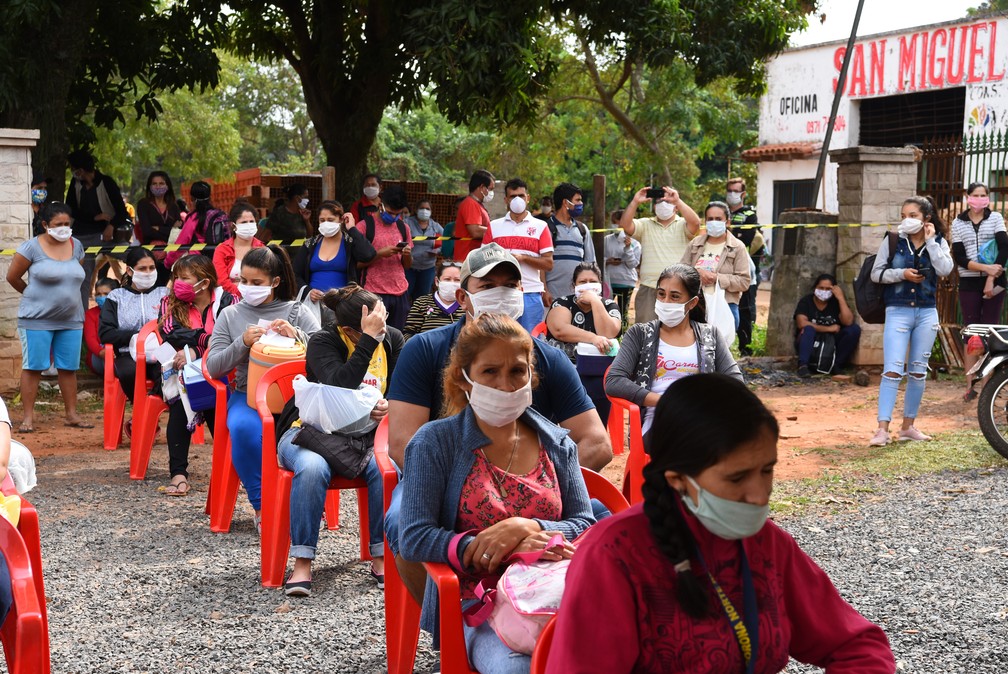 Com máscaras, paraguaios aguardam distribuição de alimentos em Assunção, no Paraguai, na sexta-feira (1º) — Foto: Norberto Duarte/AFP