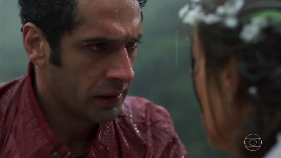 Beto (João Baldasserini) tenta tirar Tancinha (Mariana Ximenes) da chuva - 'Haja Coração' — Foto: Globo