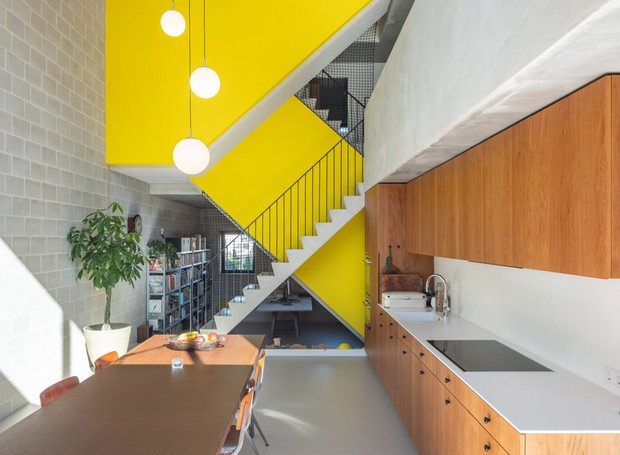 Na cozinha, a marcenaria e o concreto compartilham a mesma parede e servem como divisória entre os cômodos (Foto:  Ossip van Duivenbode/ Dezeen)