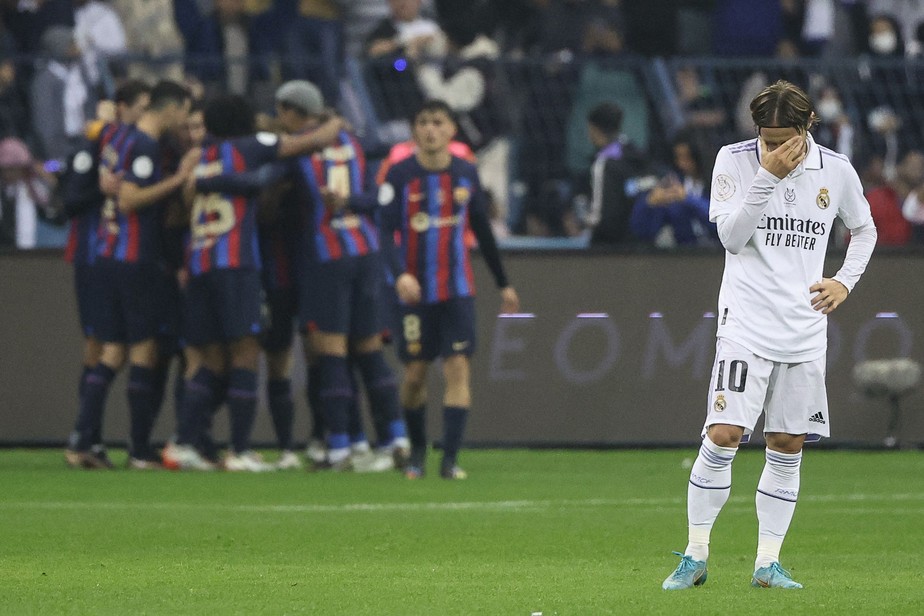 Modric, do Real Madrid, leva a mão ao rosto após o gol do Barcelona