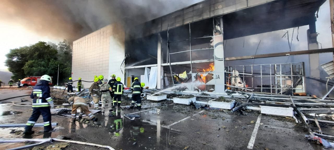 Bombeiros apagam fogo em um shopping atingido por um ataque de mísseis russos na cidade ucraniana de Kremenchuk — Foto: SERVIÇO DE IMPRENSA DO MINISTÉRIO DE EMERGÊNCIA DA UCRÂNIA / AFP