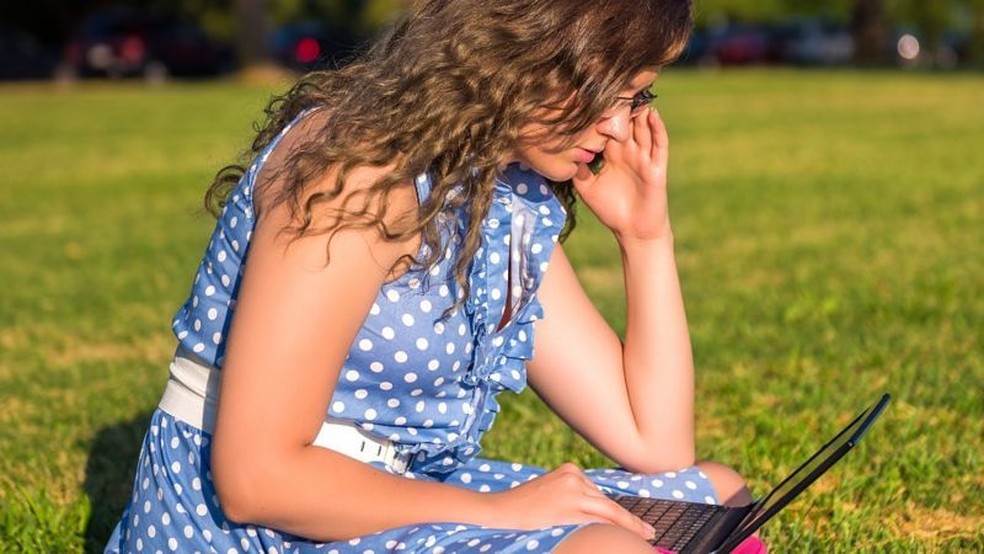 Em um estudo, quando o laptop estava no chão, e as pessoas estavam curvadas, 'elas se lembravam mais de palavras negativas do que positivas' — Foto: Getty Images via BBC News Brasil