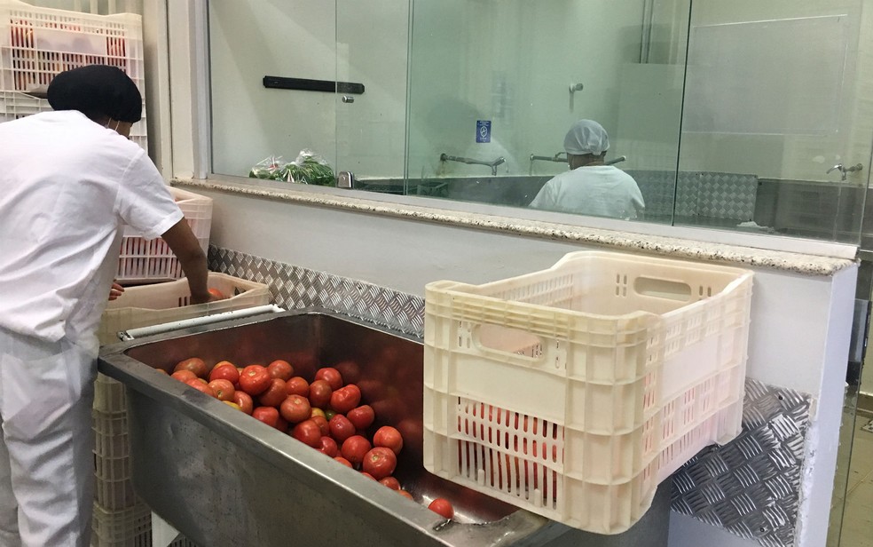 Funcionárias do restaurante universitário da UnB fazem a higienização de frutas e legumes (Foto: Luiza Garonce/G1)
