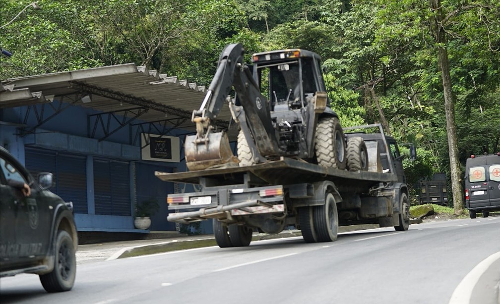 Comboio do Bope com ambulância e escavadeira subindo a serra — Foto: Marcos Serra Lima/g1