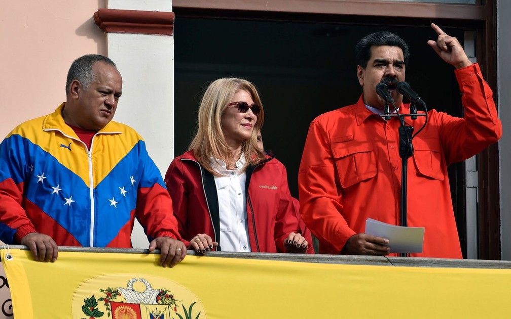 O presidente da Venezuela, NicolÃ¡s Maduro, fala da sacada do PalÃ¡cio Miraflores, em Caracas, ao lado de sua mulher, Cilia Flores, e do presidente da Assembleia Constituinte, Diosdado Cabello, na quarta-feira (23) â€” Foto: Luis Robayo/AFP