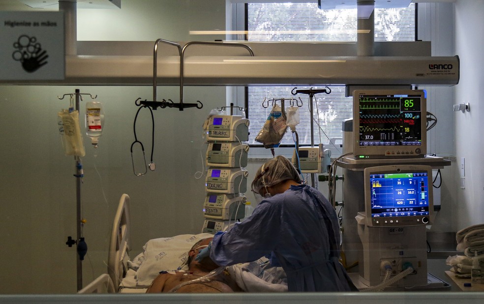 Profissional de saúde cuida de paciente na UTI do Emílio Ribas, centro de referência para tratamento de Covid-19 em São Paulo. — Foto: Miguel Schincariol/AFP