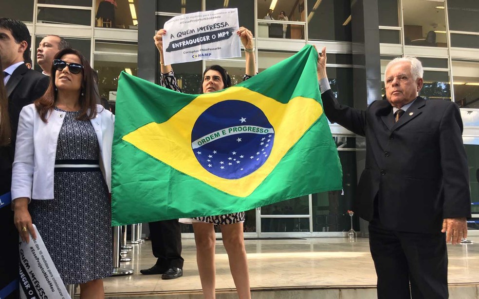 Magistrados exibem bandeira do Brasil e cartaz durante protesto contra mudanças no pacote corrupção (Foto: Luiza Garonce/G1)