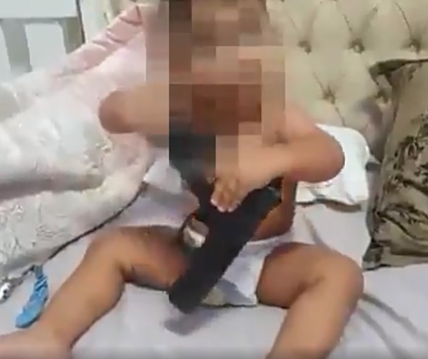 Bebê de 5 meses brinca com arma (Foto: Reprodução Twitter)