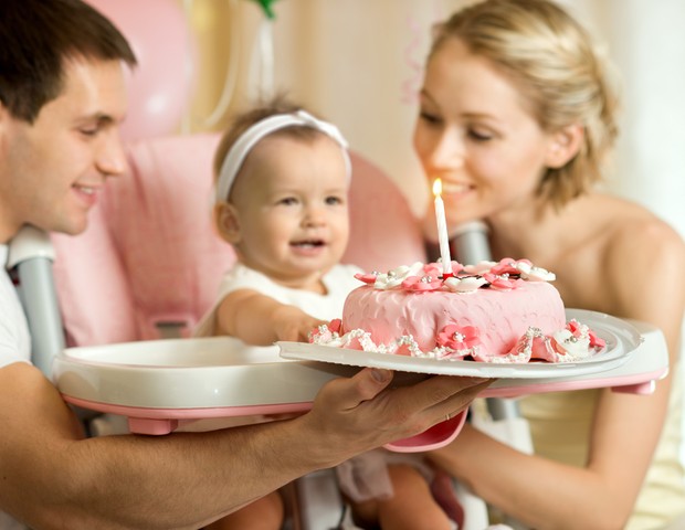 Criança e pais comemorando aniversário (Foto: Shutterstock)