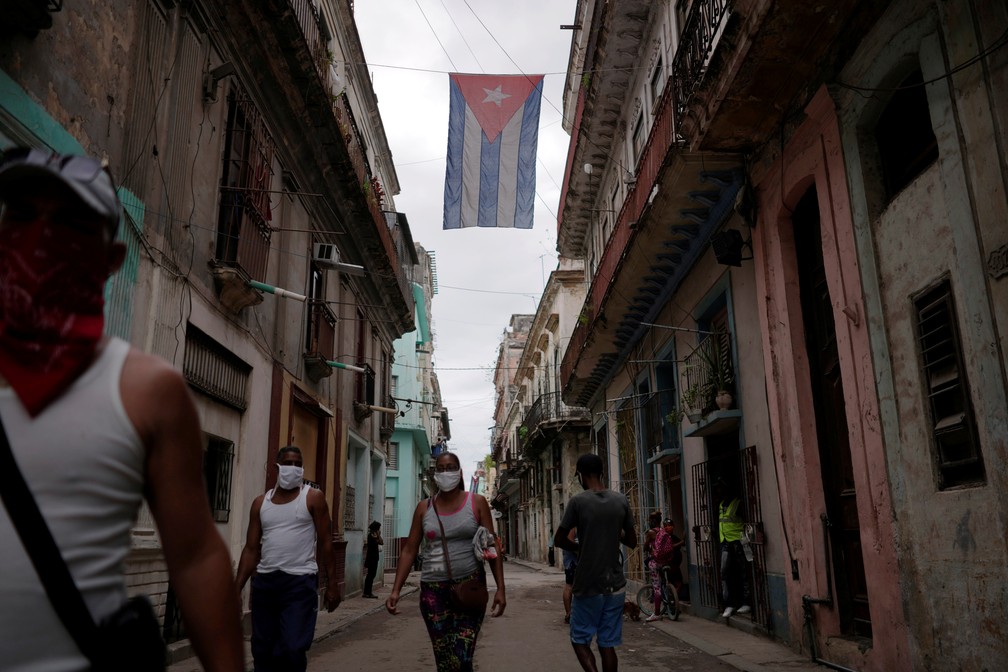 Pessoas co máscaras caminham pela Cidade Velha de Havana — Foto: Reuters/Alexandre Meneghini