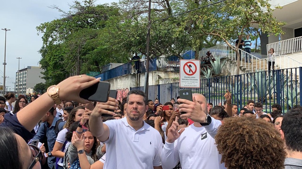 Deputados Rodrigo Amorim (E) e Daniel Silveira tiram selfies após visita ao Colégio Pedro II de São Cristóvão — Foto: Matheus Rodrigues/G1