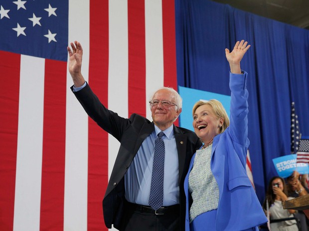 A candidata do partido democrata Hillary Clinton e o senador Bernie Sanders acenam durante um comício de campanha em Portsmouth, nos EUA, onde Sanders declarou apoio à Clinton nas eleições presidenciais (Foto: Brian Snyder/Reuters)