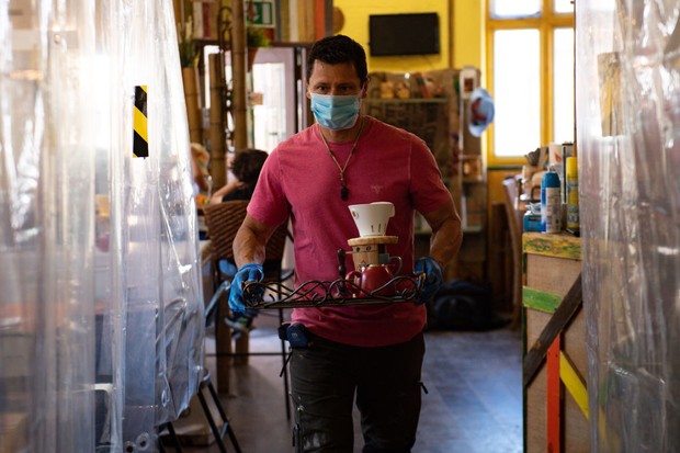 Cafe owner Francini Osorio serves customers in a trial phase during the coronavirus lockdown. Osorio has installed an air purifier and 35 clear shower curtains, which will divide customers and tables, in the Francini Cafe De Colombia, Worcester, ready for (Foto: PA Images via Getty Images)
