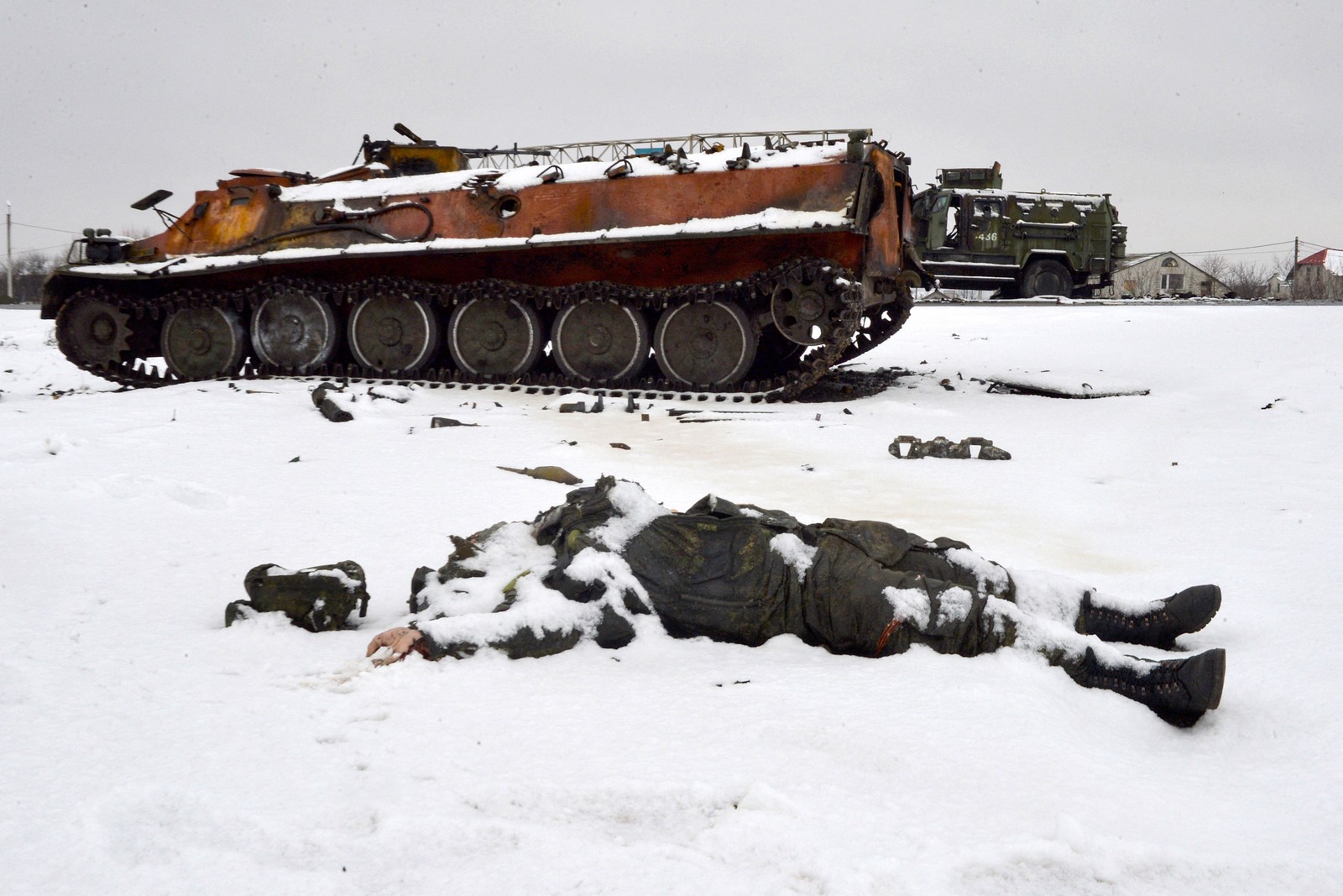 Corpo de um militar russo é visto perto de tanques de guerra destruídos na beira da estrada nos arredores de Kharkiv, em 26 de fevereiro, após a invasão russa da Ucrânia. — Foto: Sergey BOBOK / AFP