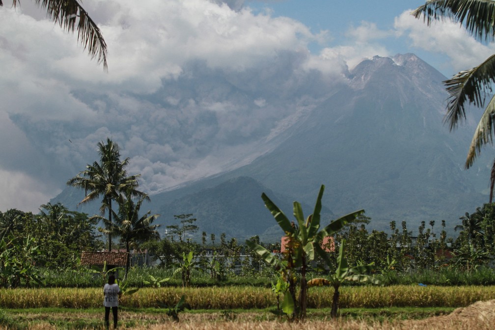 Mulher observa erupção do vulcão Merapi, na Indonésia. — Foto: Reuters