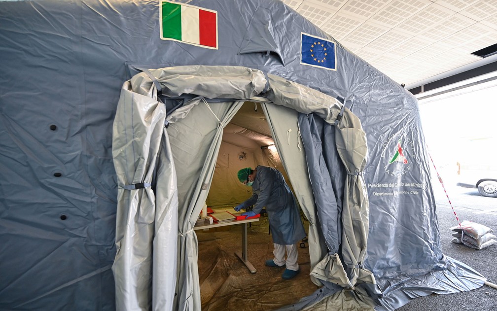  Médico usando roupa de proteção e máscara é visto em tenda onde pacientes passam por triagem no hospital Policlinico di Tor Vergata, em Roma, na terça-feira (7) — Foto: Andreas Solaro/AFP 