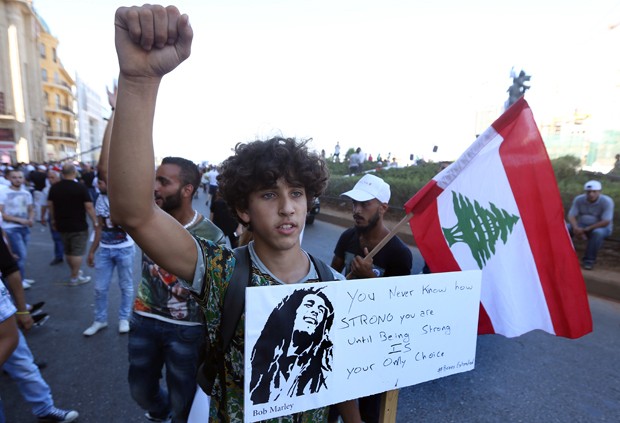 Jovem libanês leva placa para protesto contra corrução e incompetência dos políticos em Beirute, no Líbano (Foto: Anwar Amro/AFP)