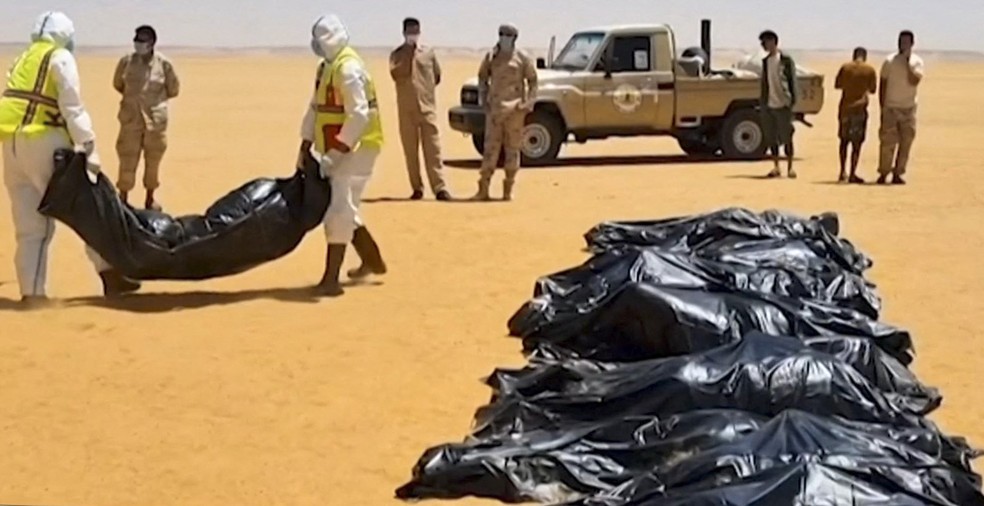 Imagem de corpos em fileira no deserto da Líbia, em 29 de junho de 2022 — Foto: Reprodução/Via AFP