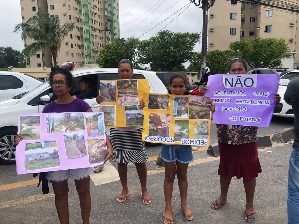 Moradores estão com cartazes para mostrar a situação das grotas após chuvas dos últimos dias em Maceió — Foto: Nick Marone/TV Gazeta