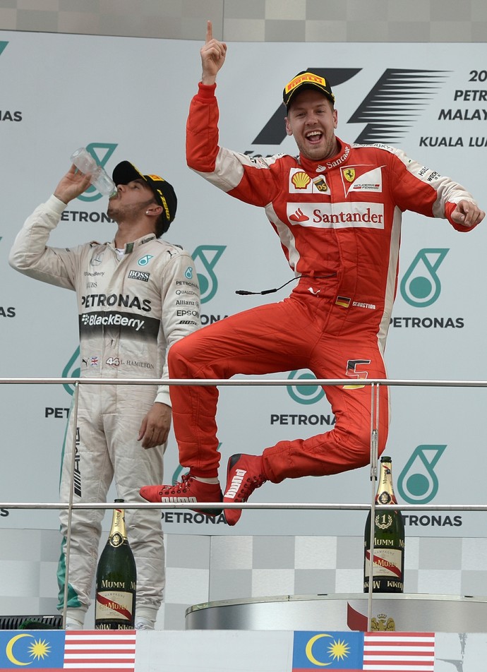 No pódio, Sebastian Vettel bate calcanhares para celebrar vitória no GP da Malásia (Foto: AFP)