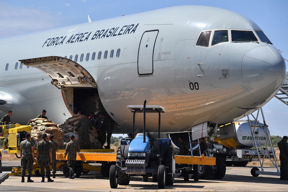Soldados brasileiros descarregam mantimentos de ajuda humanitária para a Venezuela de um avião na base aérea Ala 7, em Boa Vista (RR) — Foto: Nelson Almeida/AFP