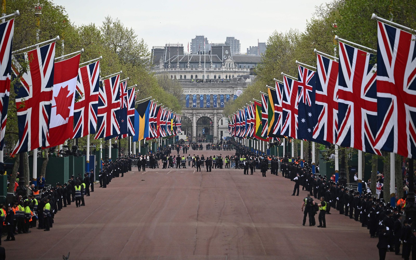 Policiais percorrem a rota da "Procissão do Rei", trecho de dois quilômetros do Palácio de Buckingham à Abadia de Westminster, no The Mall, no centro de Londres — Foto: Marco BERTORELLO / AFP