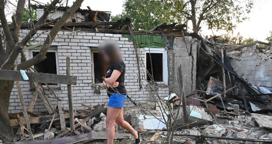 Mulher caminha próximo a destroços na cidade de Kharkiv — foto ilustrativa
