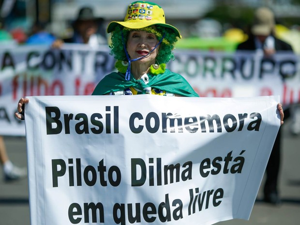 Mulher exibe faixa de protesto em Brasília (Foto: Evaristo Sá/AFP)