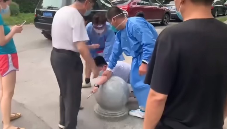 Menino é imobilizado enquanto ameaça profissionais de saúde com faca, na China (Foto: Reprodução/Yahoo News)