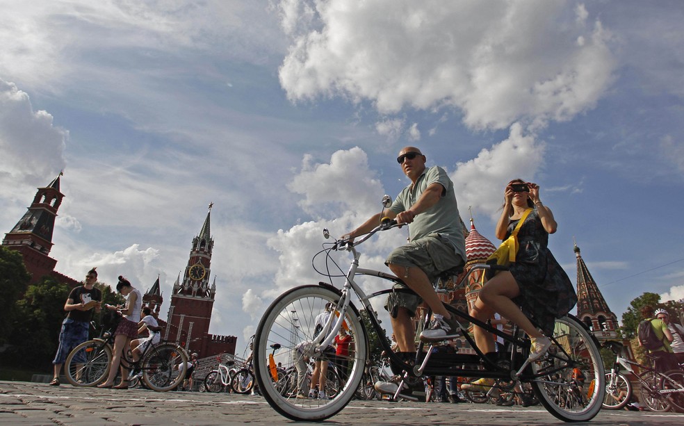 Turistas pedalam em bicicleta pelo Kremlin no centro de Moscou. — Foto: Maxim Shemetov/Reuters