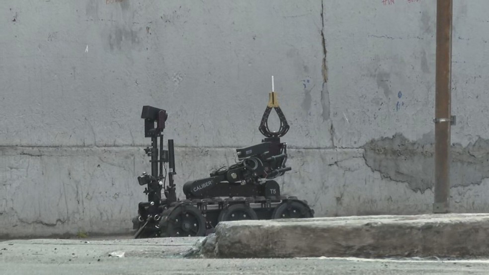 Robô da PM chegou a levar cigarro para carro onde está criminoso e casal refém — Foto: Reprodução/TV Globo