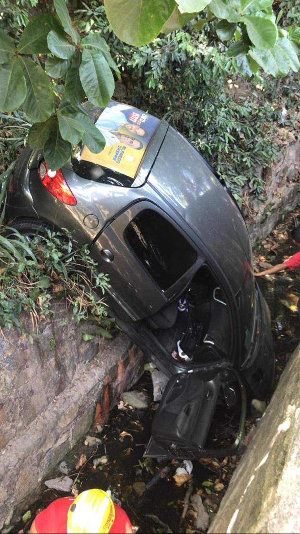 Após acidente, carro ficou caído dentro de vala na lateral da Ladeira Geraldo Melo, em Maceió — Foto: Andréa Resende/TV Gazeta