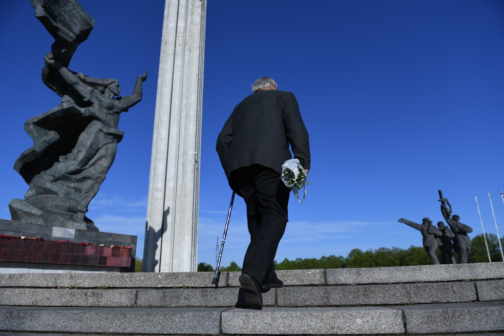 Homem chega ao monumento da vitória em Riga, na Letônia — Foto: ILMARS ZNOTINS / AFP