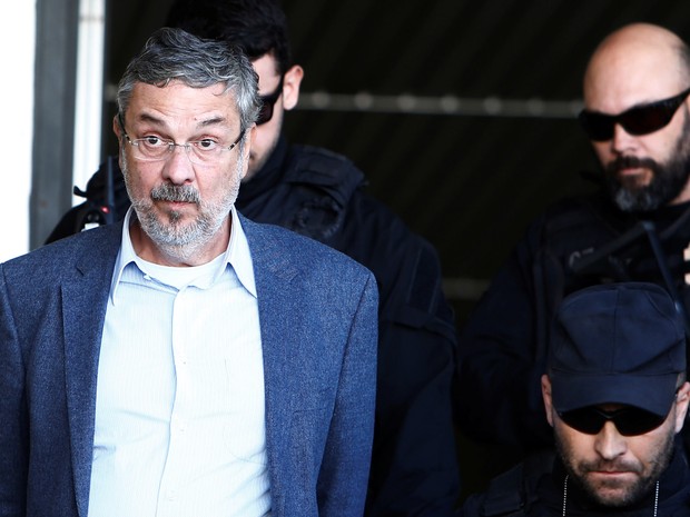 Antonio Palocci é escoltado por policiais federais enquanto deixa o Instituto de Ciência Forense em Curitiba (Foto: Rodolfo Buhrer/Reuters)