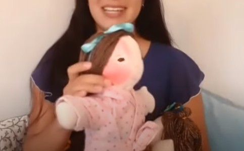 Boneca criada por Ariella Pacheco representando menina com mancha de nascença no rosto (Foto: Reprodução/YouTube)