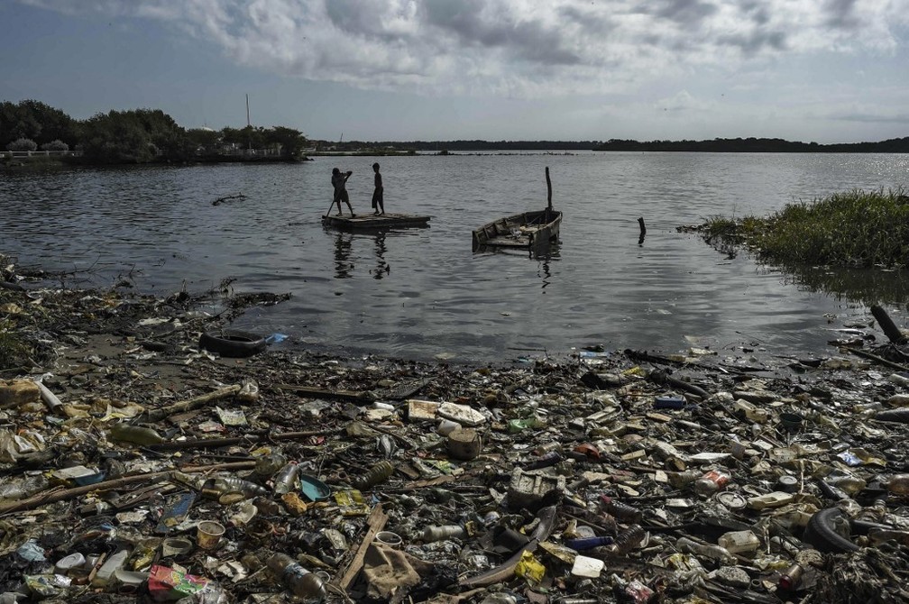 Crianas em embarcao improvisada navegam em Lago de Maracaibo, na Venezuela  Foto: Yuri Cortez/AFP