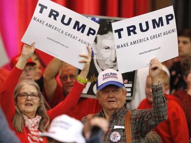 Apoiadores do candidato republicano Donald Trump seguram cartazes antes de comício do candidato em Whichita, no Kansas, neste sábado  (Foto: AP Photo/Charles Rex Arbogast)