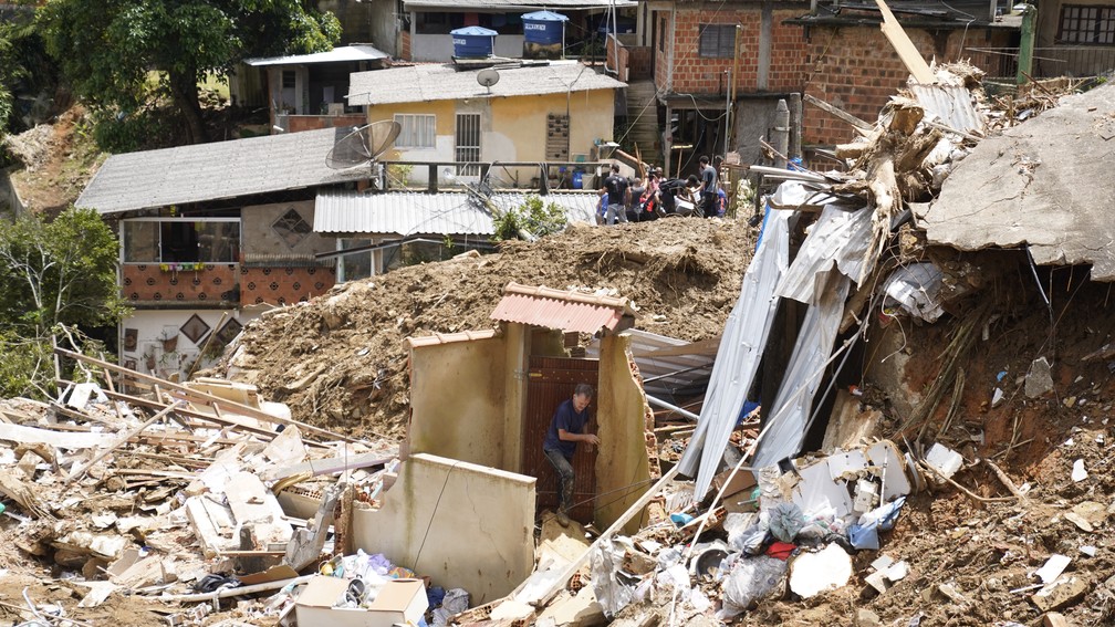 17 de fevereiro - Homem tenta abrir a porta do que sobrou de sua casa no Morro da Oficina, em Petrpolis. A cidade viveu a pior tragdia de sua histria  — Foto: Marcos Serra Lima/g1