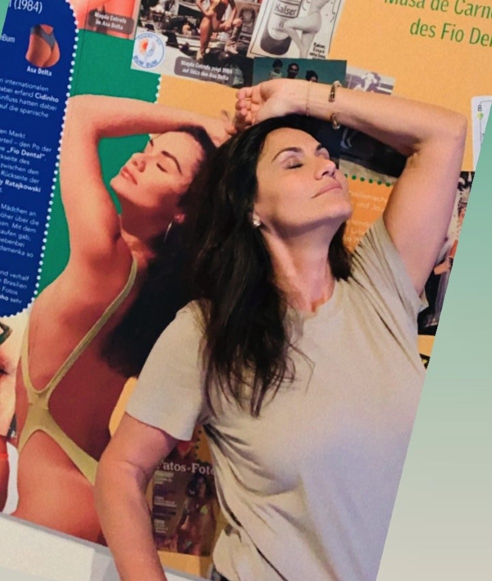 No Bikini Art Museum na Alemanha, Magda Cotrofe posa com os panéis que contam um pouco de sua história — Foto: Arquivo Pessoal
