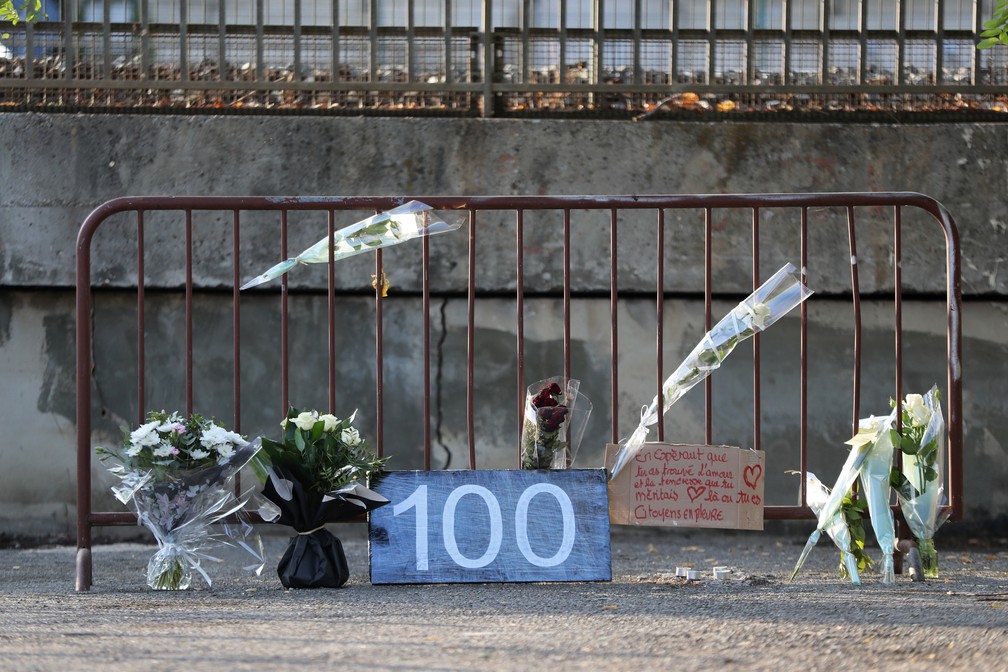A foto, de segunda-feira (2), mostra flores e uma placa com o número 100, marcando o lugar onde uma mulher foi encontrada morta em Cagnes-sur-Mer, na França. Ela foi a centésima vítima de feminicídio no país em 2019. — Foto: Valery Hache/AFP