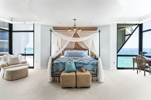  O quarto principal vem com um cantinho com mesa e vista do mar e janelas do chão ao teto (Foto: Corcoran Reverie / Reprodução)