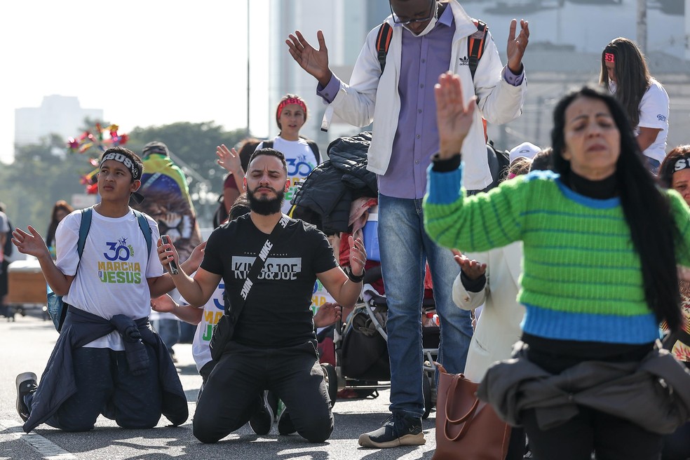 Fiéis ajoelham e fazem prece durante realização da Marcha para Jesus 2022 na cidade de São Paulo neste sábado (9). — Foto: NEWTON MENEZES/FUTURA PRESS/ESTADÃO CONTEÚDO
